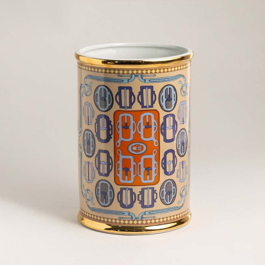 Decorative ceramic holder with golden rim and artistic geometric detailing on white background for interiors.