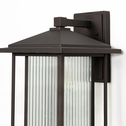 Outdoor wall lantern closeup highlighting black metal roof design and ribbed glass panel detail for classic exterior lighting style.