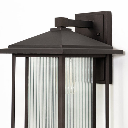 Outdoor wall lantern closeup highlighting black metal roof design and ribbed glass panel detail for classic exterior lighting style.
