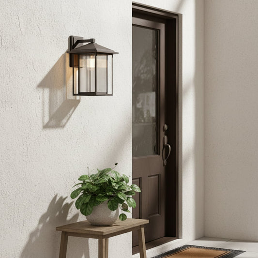 Outdoor metal wall lantern mounted beside an entry door creating warm welcoming illumination for exterior porch and house facade walls.