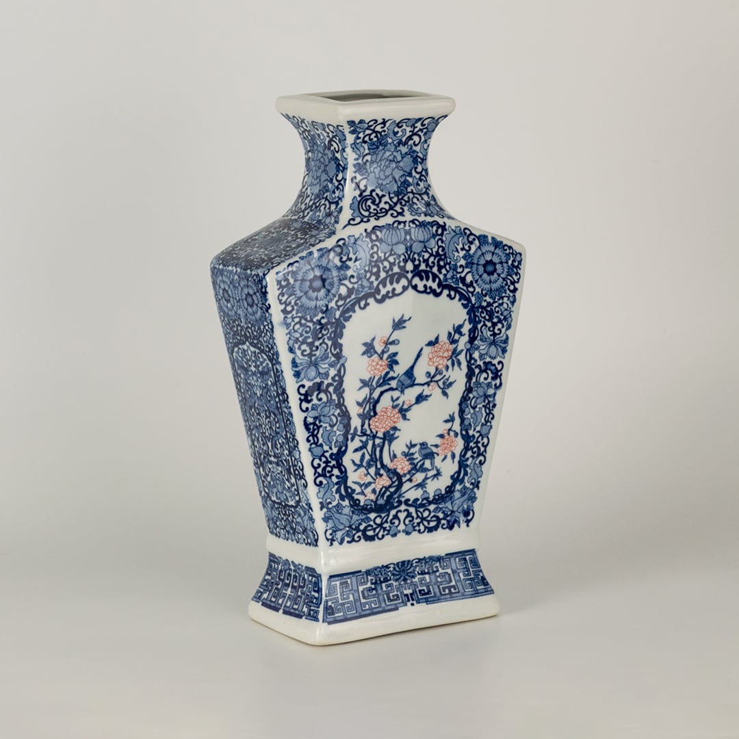 Blue and white ceramic decorative vase with floral artwork for elegant shelf styling and modern home decor displays.
