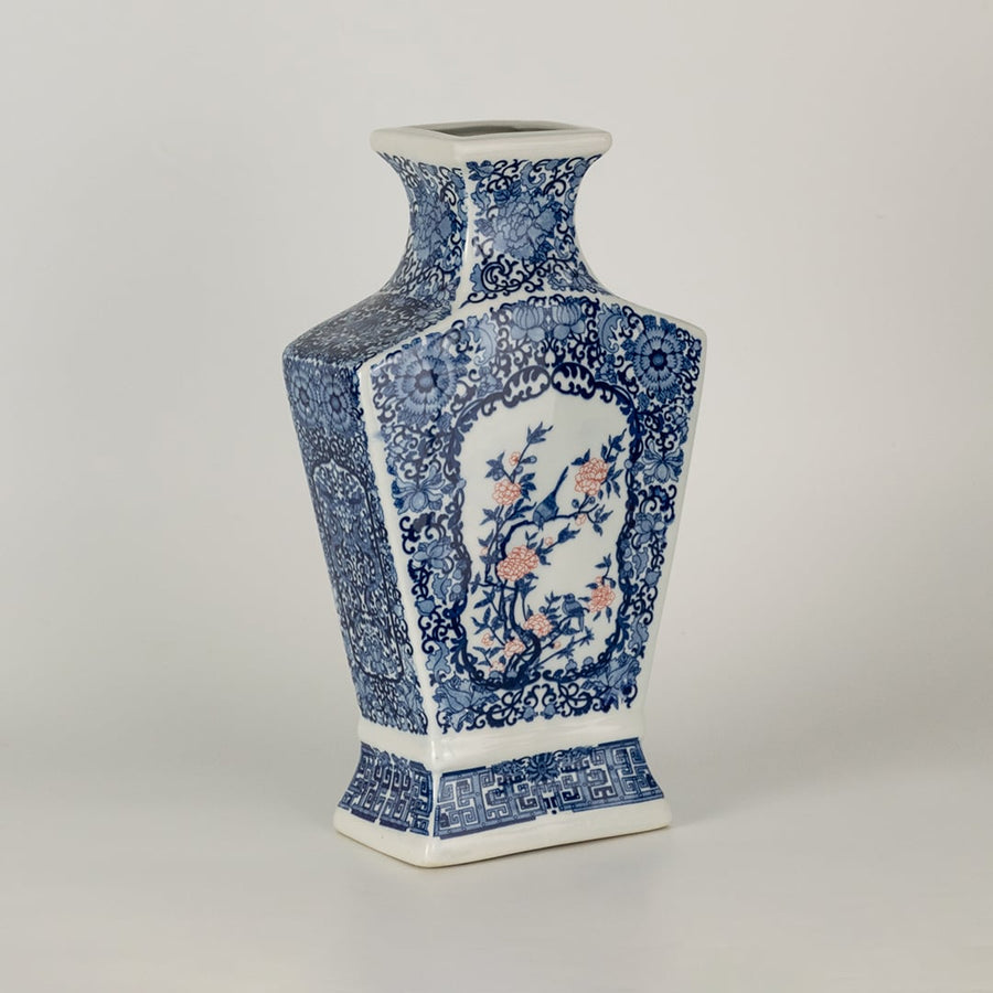 Blue and white ceramic decorative vase with floral artwork for elegant shelf styling and modern home decor displays.