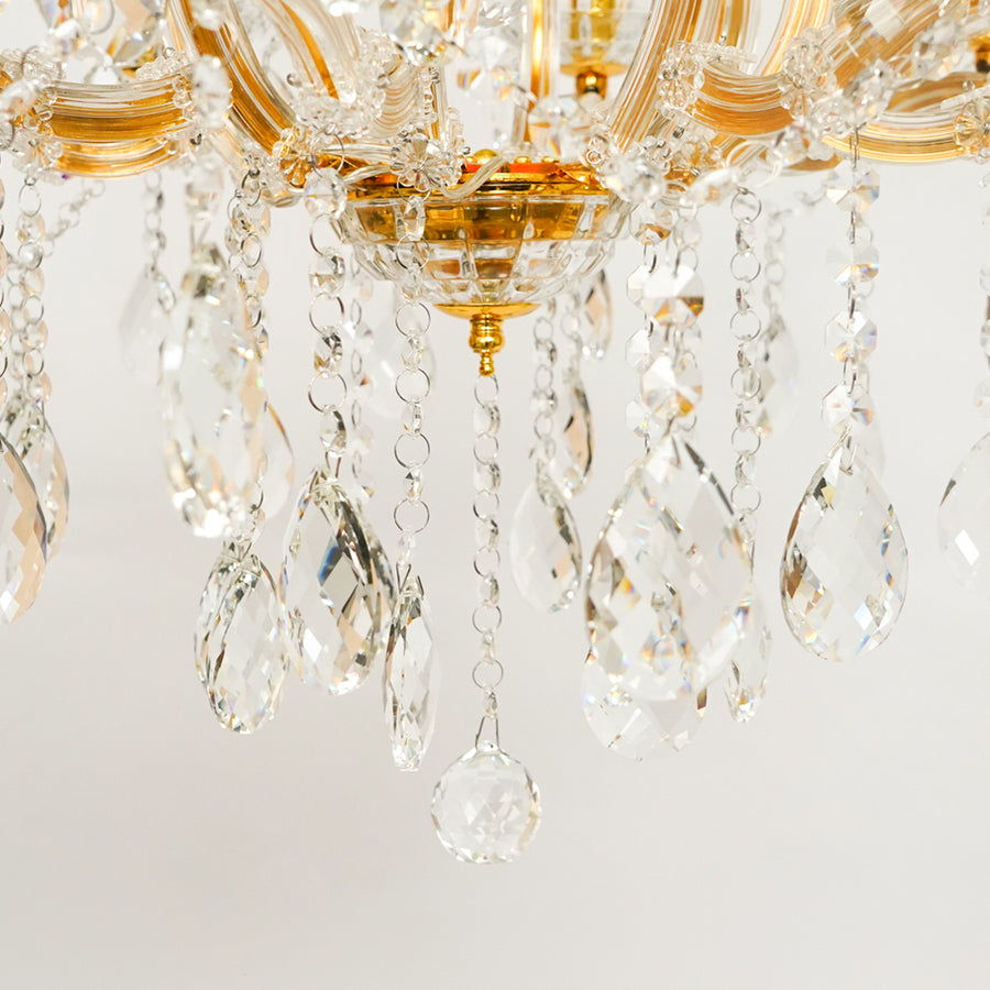 Detailed closeup image of eight light gold transparent crystal chandelier for modern ceiling decor styling with luxury look.
