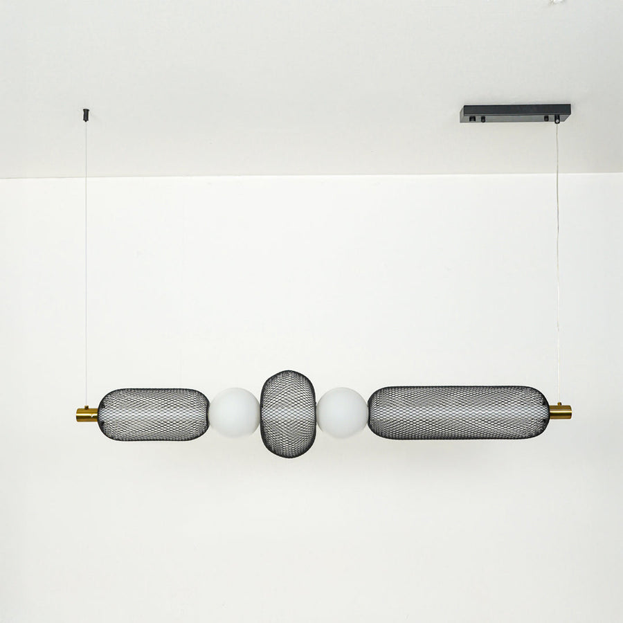 Modern wall light with textured glass cylinders and metal accents mounted on neutral wall background ideal for contemporary bathroom or hallway lighting.