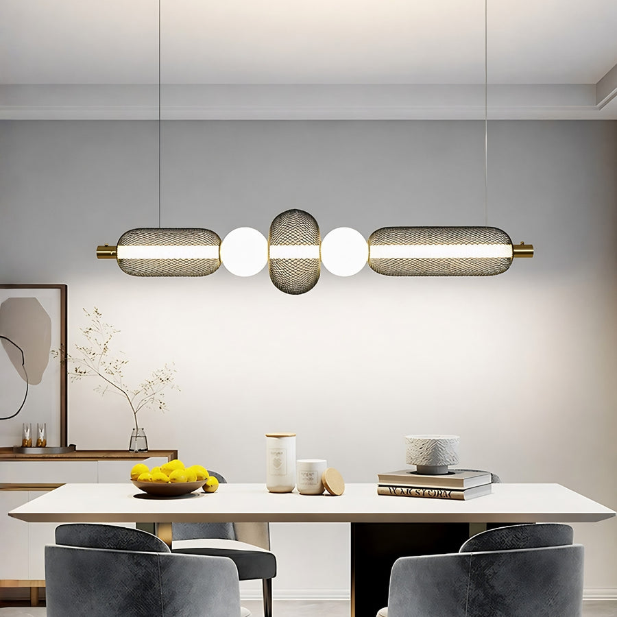 Horizontal pendant light with white glass shades and gold metal accents installed above dining table in modern kitchen interior setting.