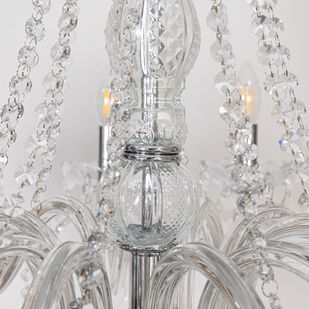Closeup of chandelier with silver finish and crystal droplets highlighting elegant decorative lighting design.