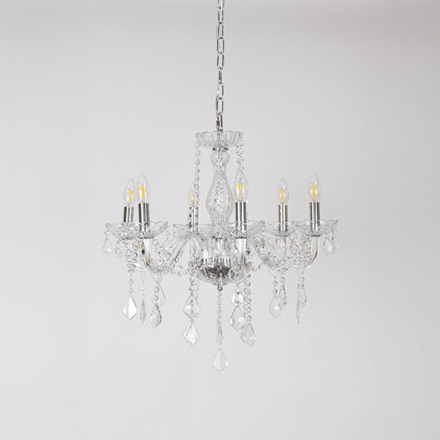 Classic chandelier with silver accents and crystal glass displayed off on white background for modern decor.