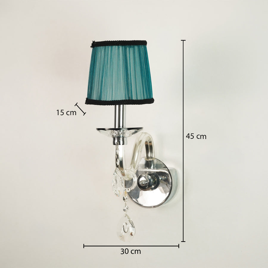 A wall-mounted light fixture with a teal pleated fabric shade, chrome metal arm and wall mount, clear hanging crystal drops, and overlaid dimension labels showing 45 cm height, 30 cm width, and 15 cm shade width on a plain light background.