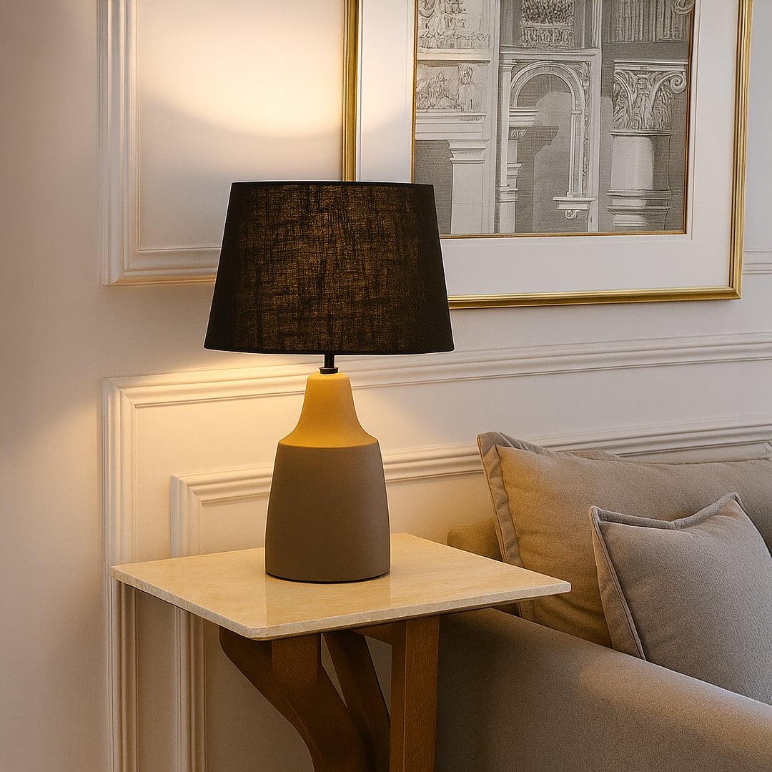 Modern table lamp with black fabric shade and smooth grey base adding warm ambient lighting that enhances stylish contemporary interior home decor settings.