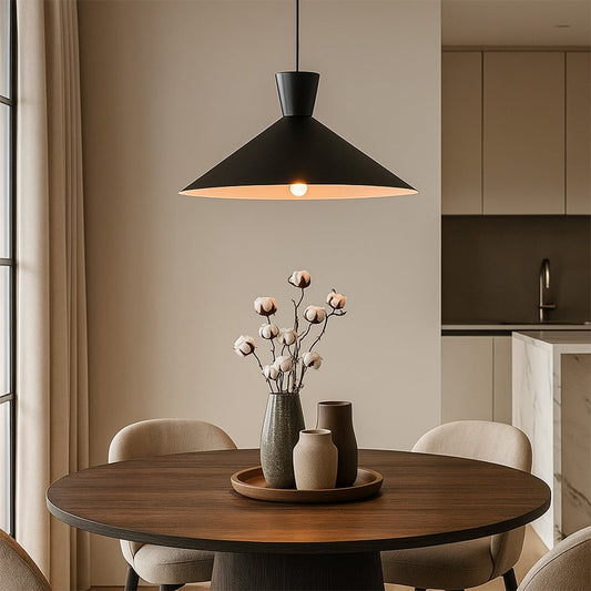Black metal pendant light hanging above wooden dining table creating focused illumination in a modern dining space.