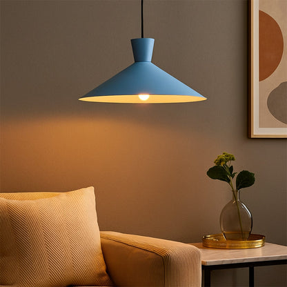 Blue cone pendant light hanging above bedside table with light on for modern colorful room décor.