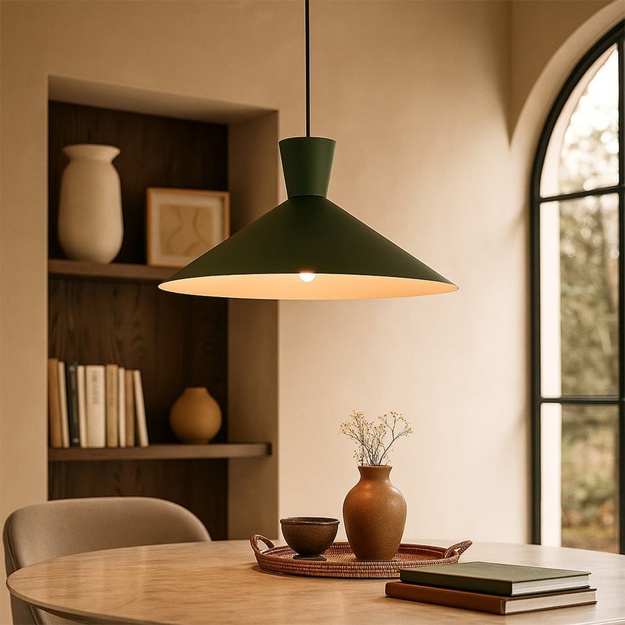 Green cone pendant light in cozy reading nook with light on for warm earthy décor.
