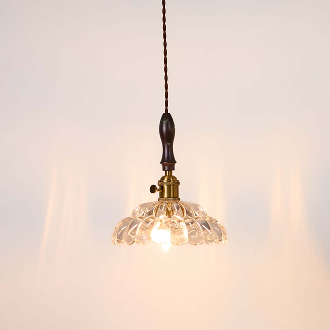 Textured clear glass and brass metal pendant light with warm glow for stylish home interiors.