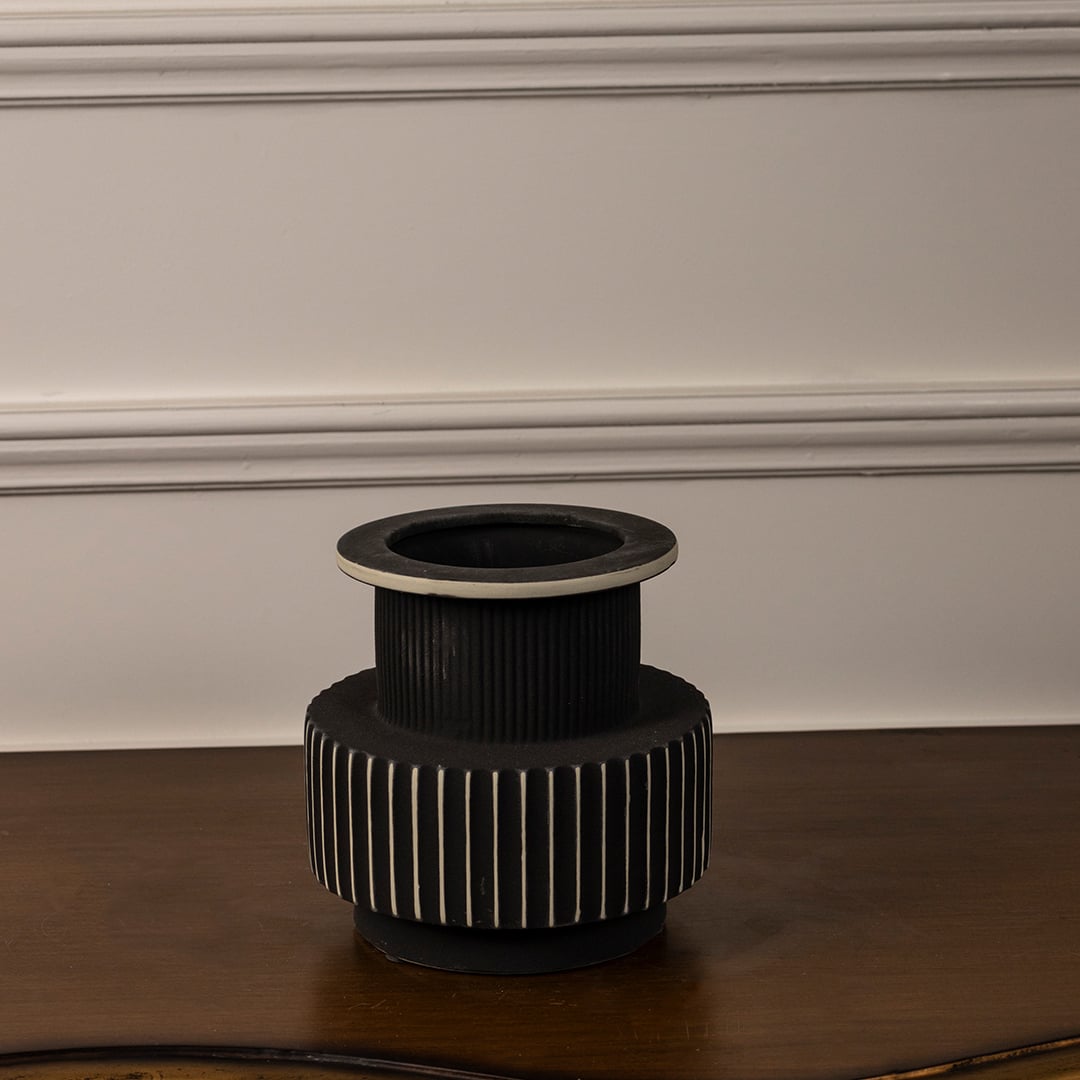 Black and white ceramic vase with ribbed surface and matte finish displayed on white background for modern home decor.