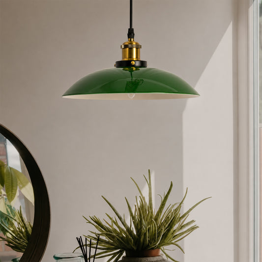 Green metal pendant light with brass accents suspended above dining table creating warm modern ambiance.