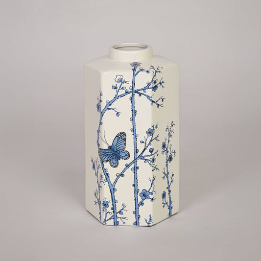 Decorative cream ceramic vase with blue flower pattern placed on white background emphasizing artistic printed surface.