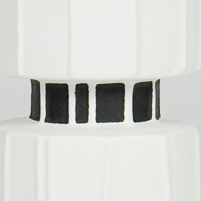 Closeup image of white ceramic striped vase for modern tabletop decor styling with bold artistic finish display.