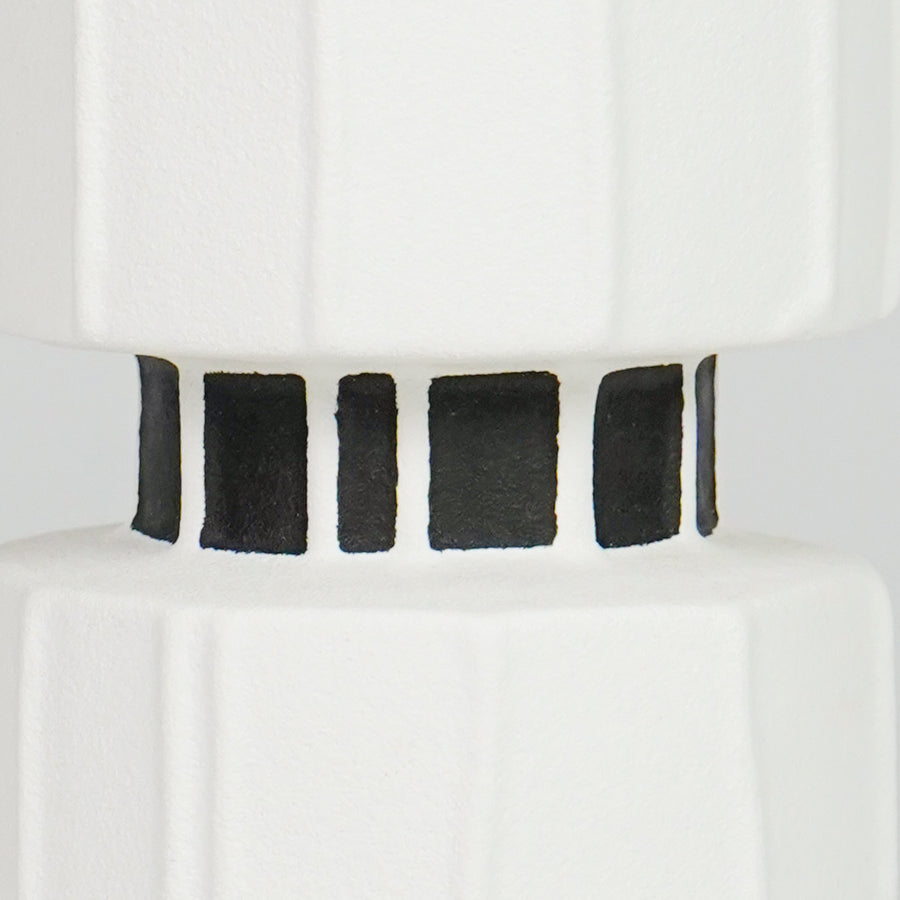 Closeup image of white ceramic striped vase for modern tabletop decor styling with bold artistic finish display.