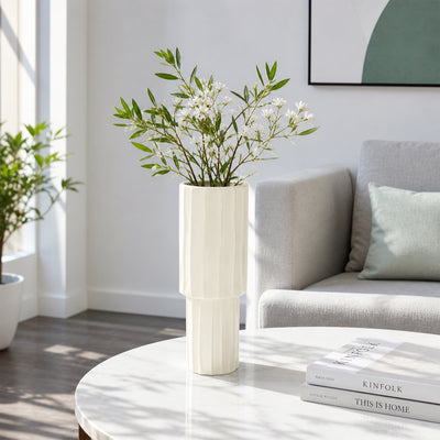 Cream ceramic flower vase with white blooms placed on marble table for elegant modern home decor styling.