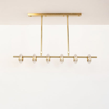 Golden metal linear chandelier with clear glass rings displayed off on white background highlighting elegant home lighting.