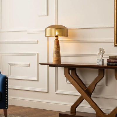 Table lamp placed on a wooden console table with classic wall paneling creating a warm elegant interior setting.
