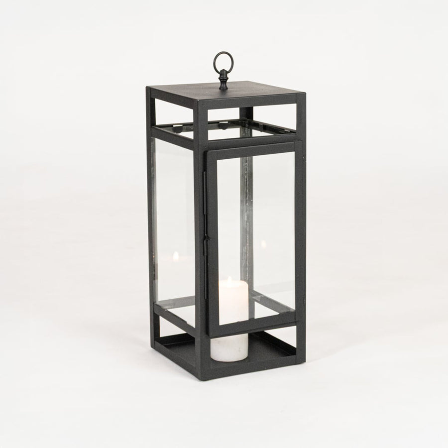 Minimal black metal candle lantern with transparent glass panels on white background perfect for home festive and patio Decor.