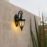 Vintage black metal scroll outdoor wall lantern light with patterned glass for courtyard stone boundary wall decoration.