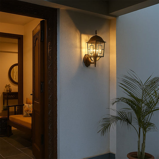 Outdoor wall lantern in black metal with clear glass mounted beside entrance door adding warm welcoming glow to exterior home decor.