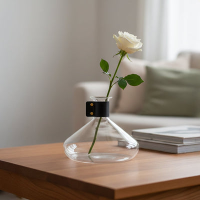 Clear glass decorative vase styled with white flowers on a wooden table for elegant modern home decor settings.