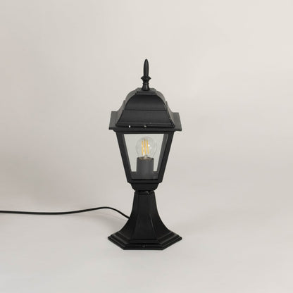Classic black pillar lamp with clear glass panels shown with light off on white background for outdoor garden lighting.