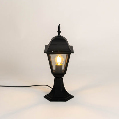 Classic black metal gate light with warm glowing bulb for modern outdoor decor styling use.