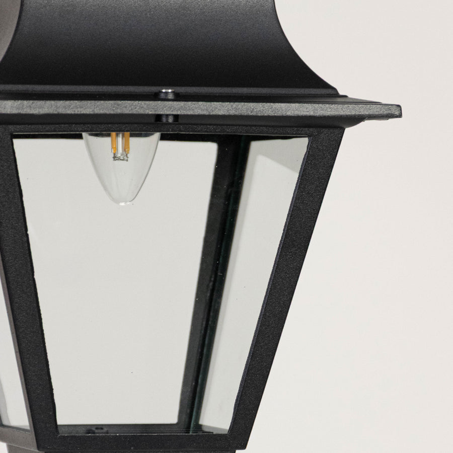 Contemporary black metal lantern pendant light with clear glass panels for stylish porch and patio lighting.
