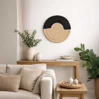 Black and natural woven wall basket displayed above a sofa for elegant bohemian wall decor and modern home interiors.