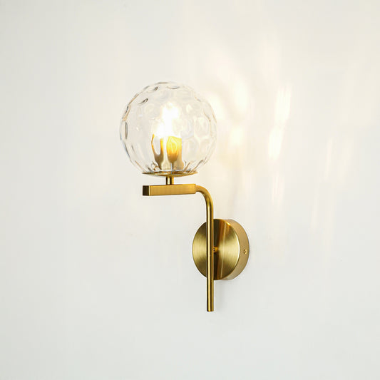 Modern gold metal wall light with clear textured glass shade for stylish hallway and premium decor spaces.