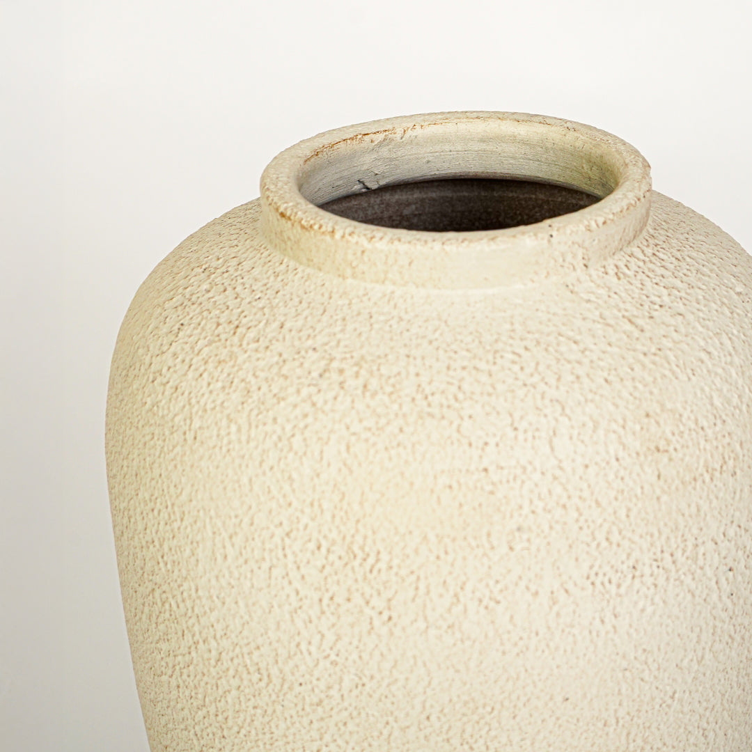 Closeup image of beige ceramic decorative vase for modern tabletop decor styling with rustic textured finish.