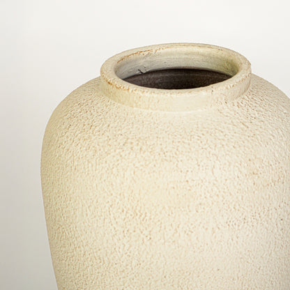 Closeup image of beige ceramic decorative vase for modern tabletop decor styling with rustic textured finish.