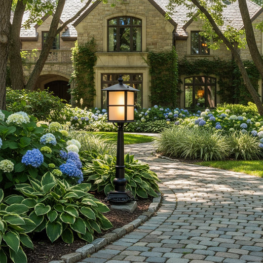 Outdoor garden post light in black metal with glass shade placed along stone pathway adding warm illumination and elegant landscape lighting.