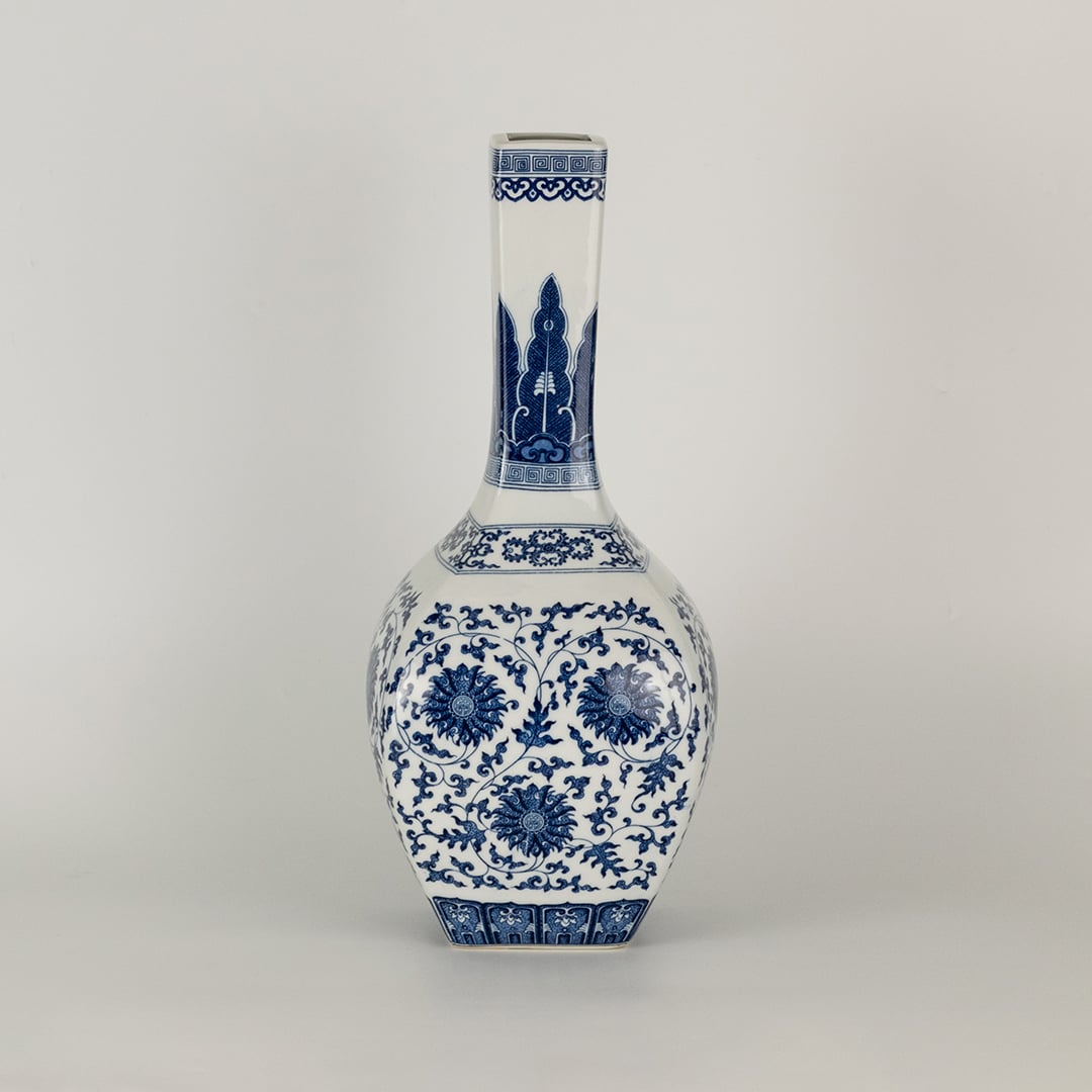 Blue and white ceramic jar with a tall narrow neck and intricate floral artwork shown in a studio setting creating a graceful artistic presence suited for elegant decor.