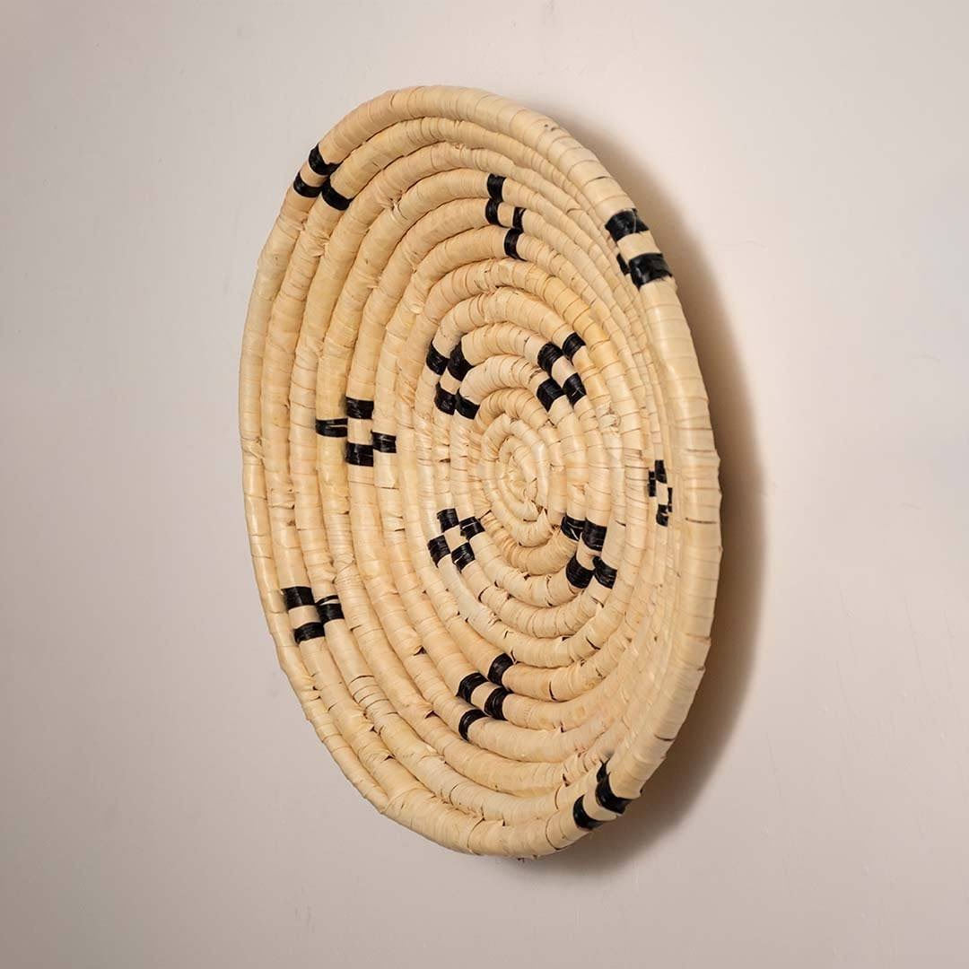 Side view of handcrafted natural cream seagrass wall basket with small black diamond patterns for bohemian home wall decor.