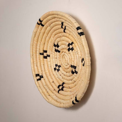 Side view of handcrafted natural cream seagrass wall basket with small black diamond patterns for bohemian home wall decor.