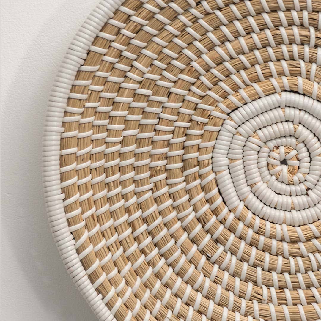 Closeup of handcrafted natural seagrass wall basket with spiral woven pattern for artisan boho home décor styling.