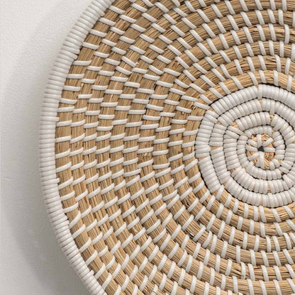 Closeup of handcrafted natural seagrass wall basket with spiral woven pattern for artisan boho home décor styling.