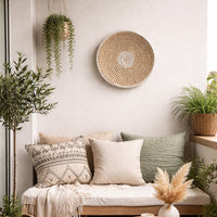 Natural woven wall basket displayed above a sofa for artistic bohemian wall decor and contemporary home interiors.