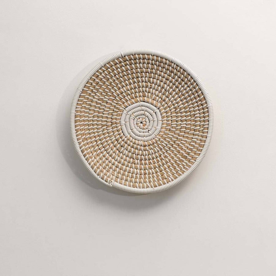 Round handcrafted natural seagrass wall basket with woven pattern for boho décor on white background image.