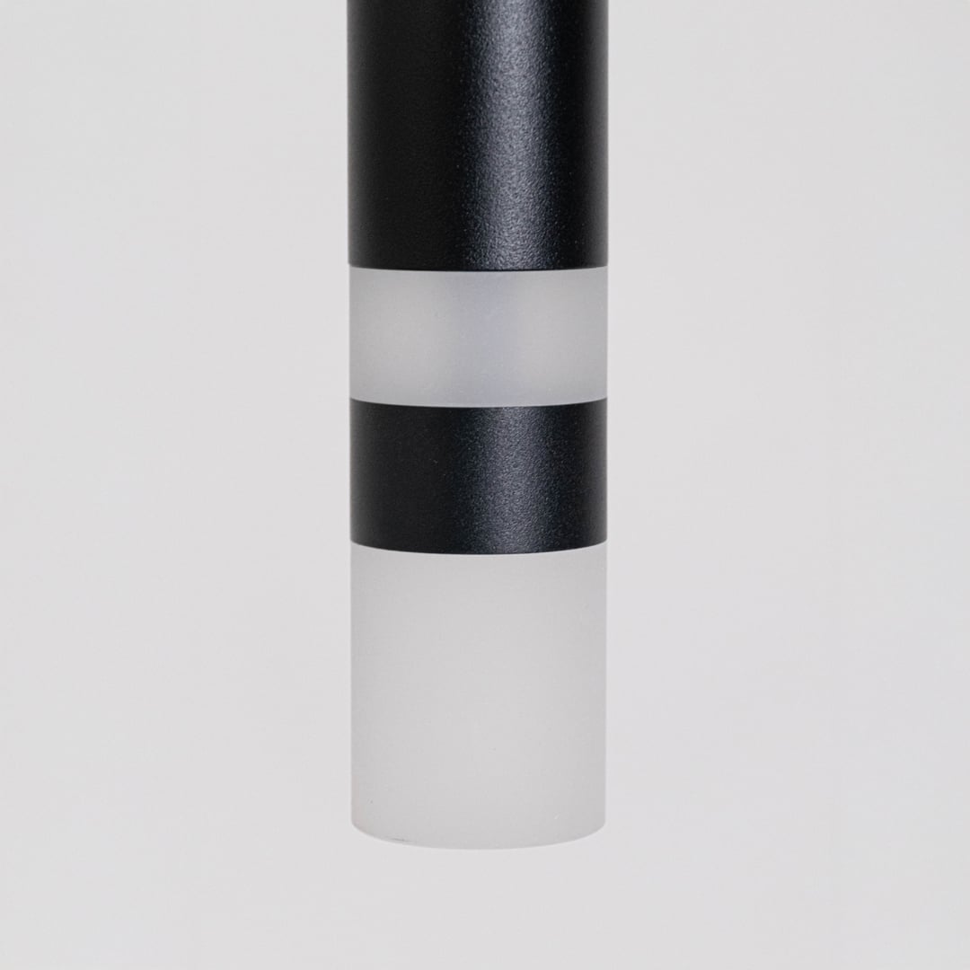 Closeup of elegant black cylindrical pendant light showing smooth matte finish and premium craftsmanship detailing.
