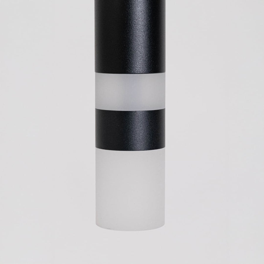 Closeup of elegant black cylindrical pendant light showing smooth matte finish and premium craftsmanship detailing.