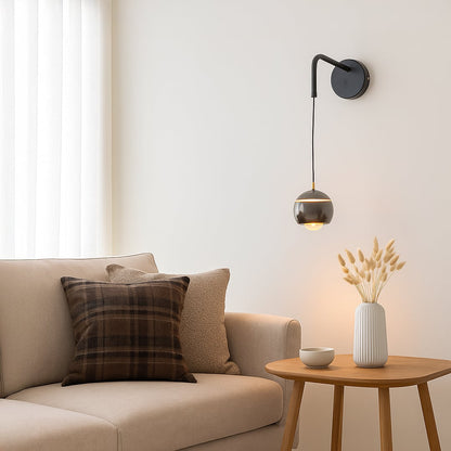 Table lamp style wall light shown in a bright lifestyle view with a modern hanging globe shade adding soft ambient lighting to interior spaces.