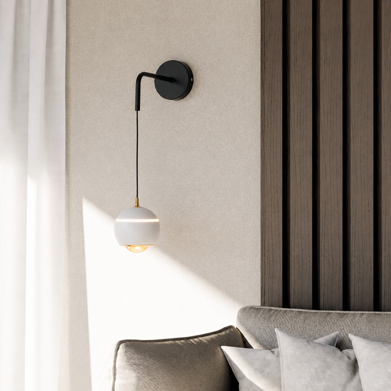 A modern wall-mounted sconce with a black metal arm and a white spherical shade, shown lit in a styled interior next to a sofa and textured wall paneling.
