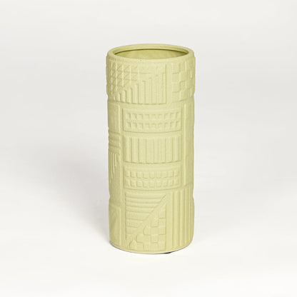 Yellow ceramic textured cylindrical vase with carved geometric detailing isolated on white background for contemporary home decor use.
