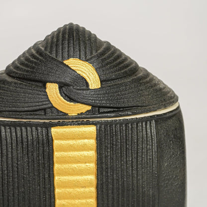 Black ceramic decorative jar with textured surface and gold accent lid perfect for jewelry storage and stylish interior decor.